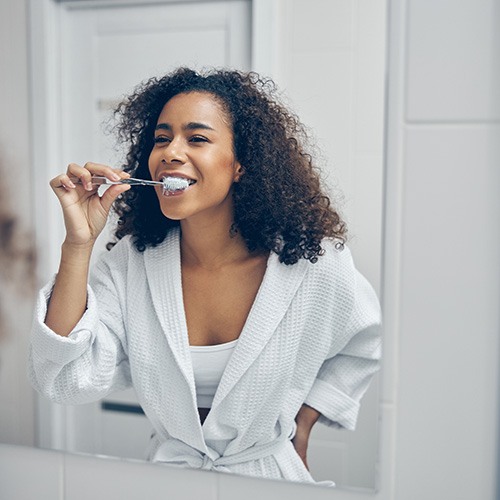 Patient in Chicago brushing their teeth after teeth whitening